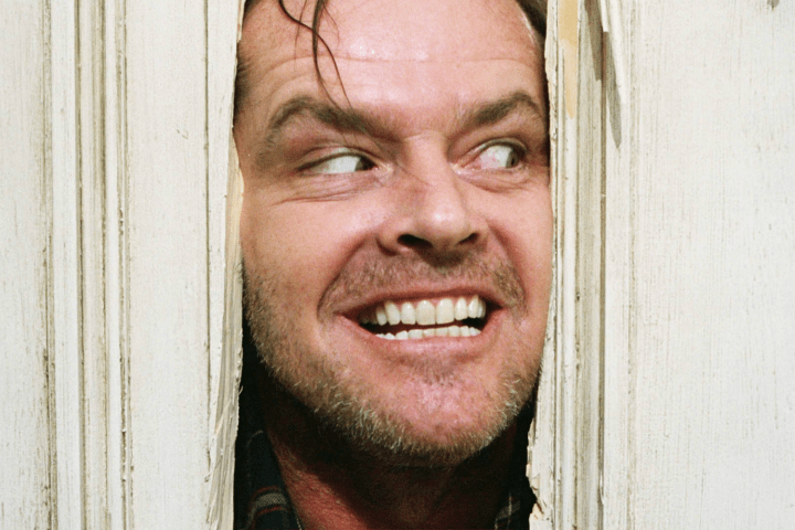 Jack Torrance looking through a hole in a door in "The Shining."