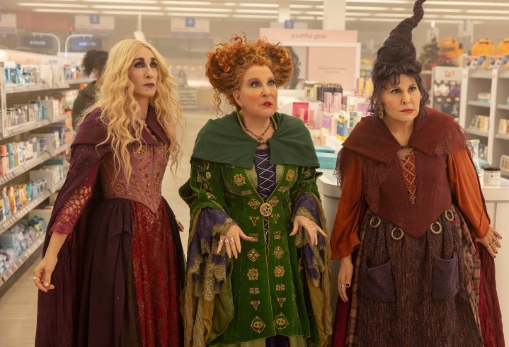 Sarah Jessica Parker, Bette Midler, and Kathy Najimy stand in a convenience store in a scene from Hocus Pocus 2.