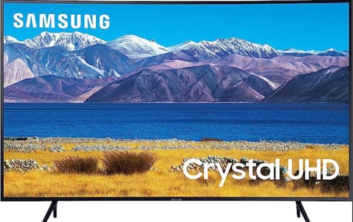A Samsung TV displays a lake and mountain scene.