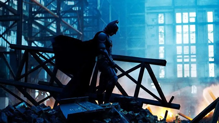 Batman (Christian Bale) standing amid wreckage in The Dark Knight.
