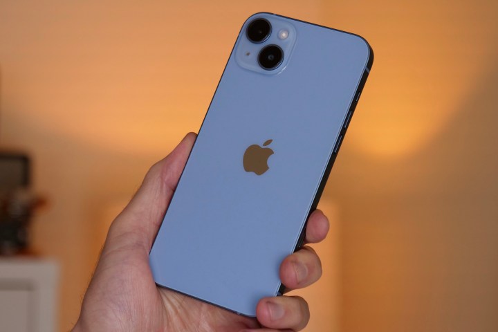 The iPhone 14 Plus held in a man's hand.