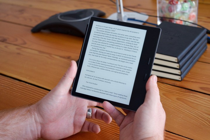 A man reads a text on an Amazon Kindle Oasis. 