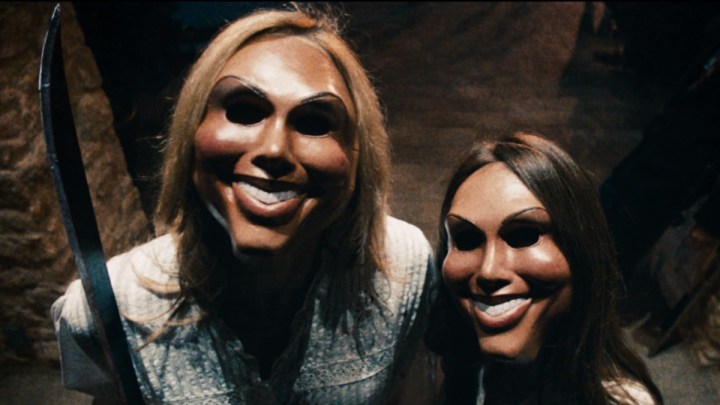Two intruders with masks on hold up weapons in The Purge.