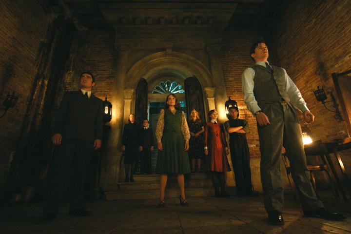 Hercule Poirot's suspects stand together in a chamber in A Haunting in Venice.