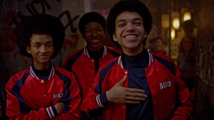 Two young men smiling in red jackets, one with his hand to his chest in a scene from The Get Down.