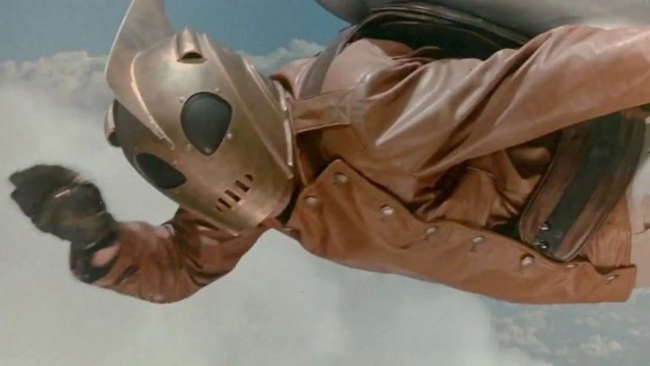A man flies in the blue sky in The Rocketeer.