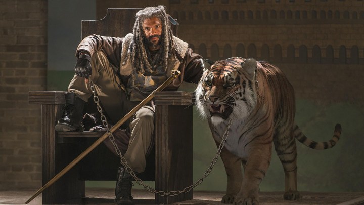 Ezekiel from The Walking Dead sitting on his throne, leg up with Shiva the tiger beside him.