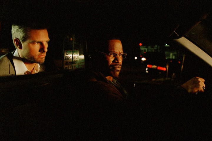 Tom Cruise sits behind Jamie Foxx in a taxicab in Michael Mann's Collateral.