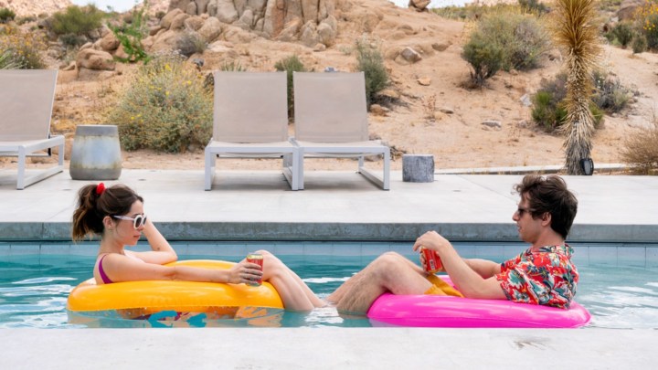 Cristin Milioti and Andy Samberg sitting across from each other in a pool.