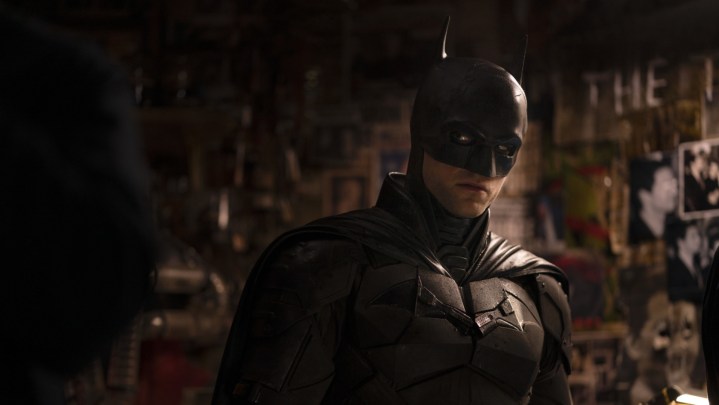 Robert Pattinson as Batman in a dimly lit crime scene.