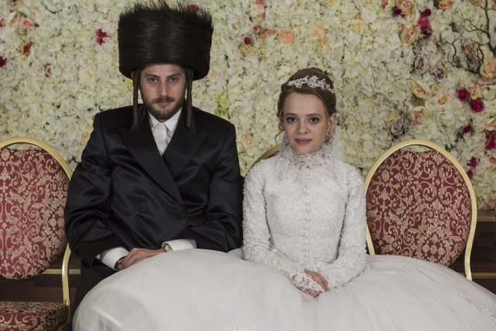 A Jewish couple pose for wedding photos.