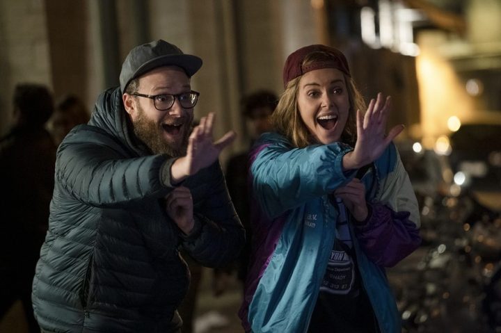 Seth Rogen and Charlize Theron wave hi in Longshot.