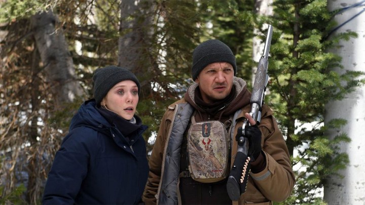 Elizabeth Olsen and Jeremy Renner as Jane and Cory in the forest in the film Wind River.