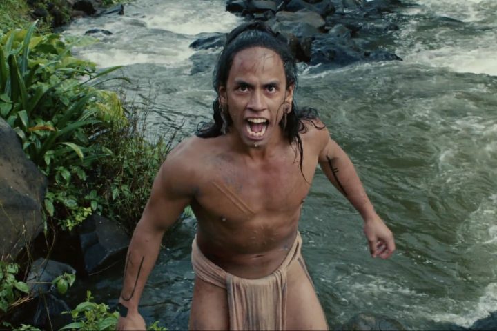 A warrior stands outside the river and screams in Apocalypto.