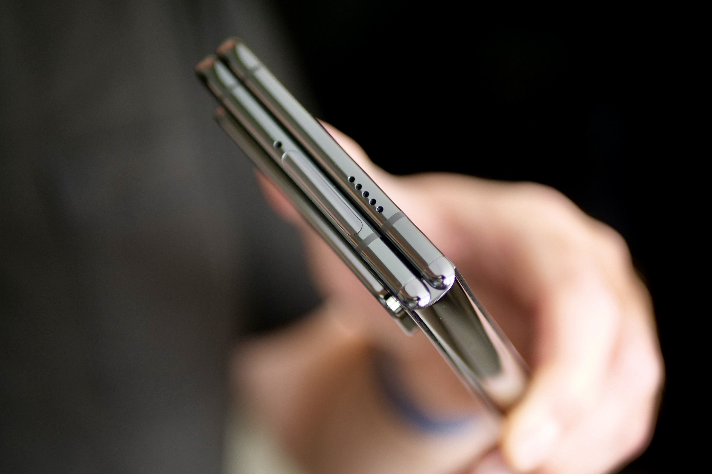 A person holding the Google Pixel Fold showing the top of the closed phone.