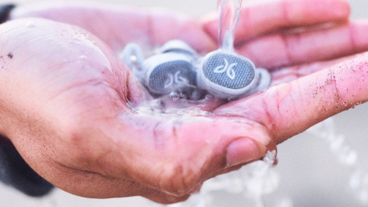 Jaybird Vista 2 earbuds in palm with water pouring.