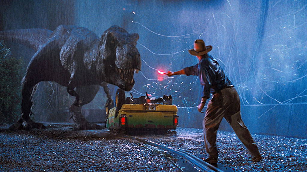 A still from Jurassic Park in which Sam Neill's character tries to lure away a T-Rex with a flare.