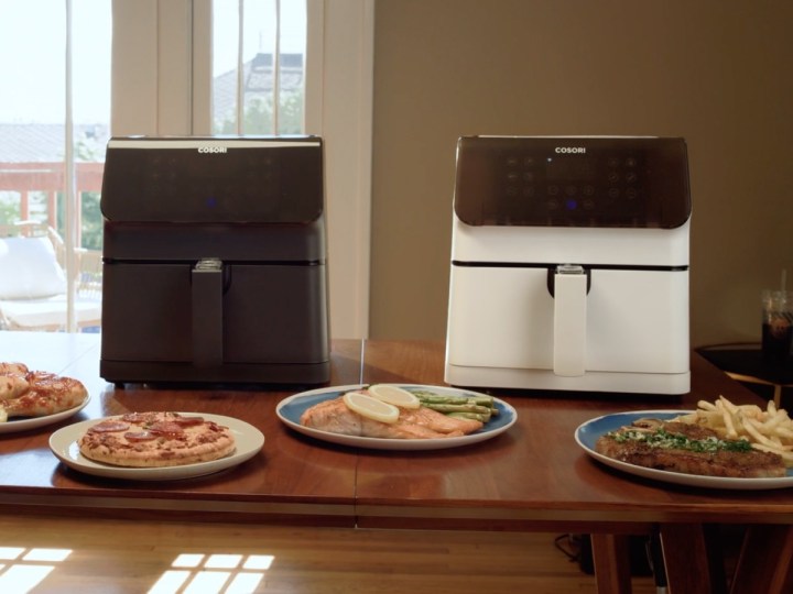 A meal laid out on a table with two Cosori Pro 2 air fryers.