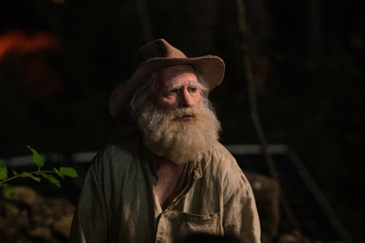 Joaquin Phoenix wears a hat and old man makeup in Beau is Afraid.