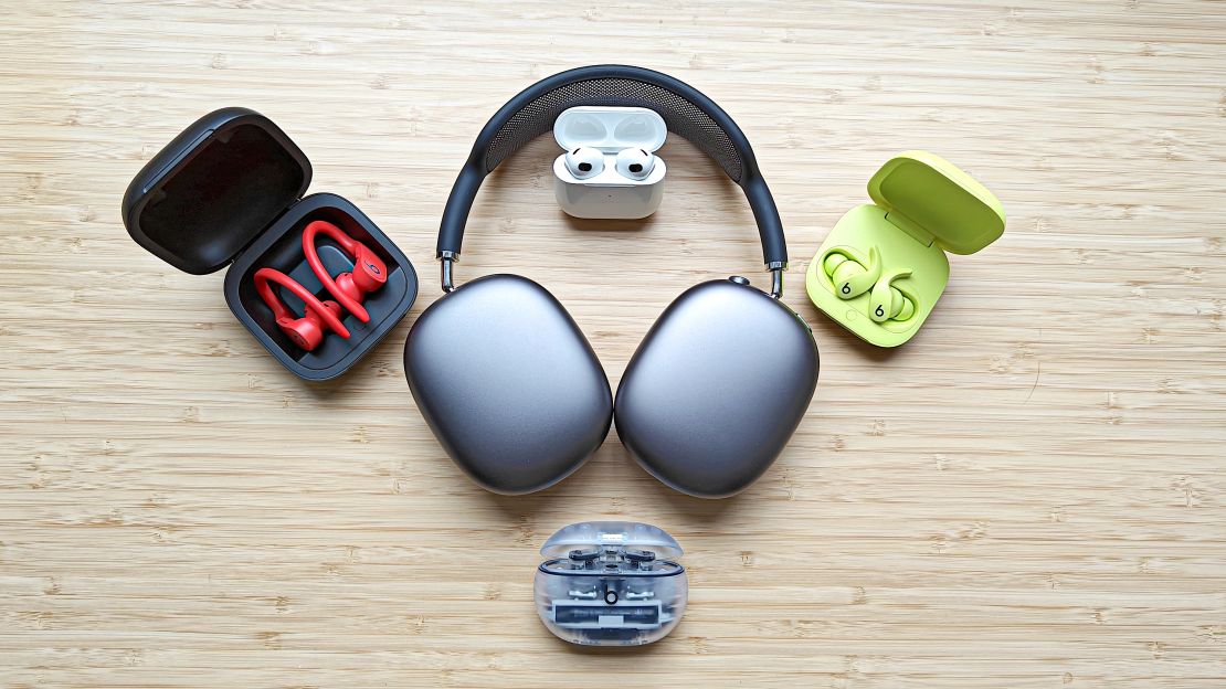 A collection of Apple and Beats headphones assembled on a wooden surface.