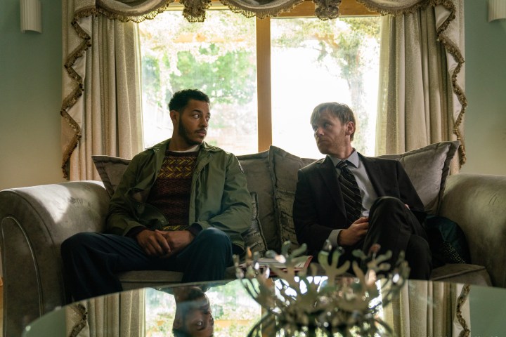 Daryl McCormack and Brian Gleeson sit on a couch together in Apple TV+'s Bad Sisters.