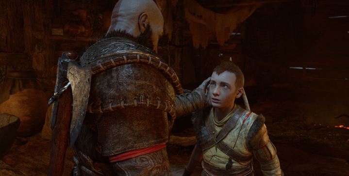 Kratos holds Atreus' face in God of War: Ragnarok.