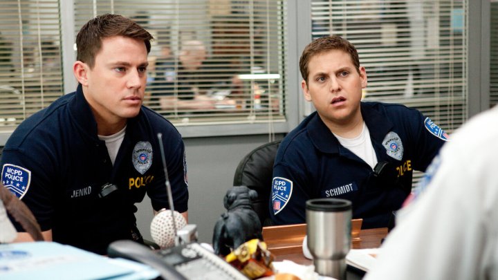 Channing Tatum and Jonah Hill sit at a desk in 21 Jump Street.