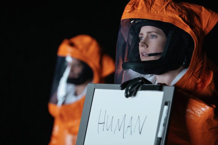 Amy Adams holds up a whiteboard sign in Arrival.