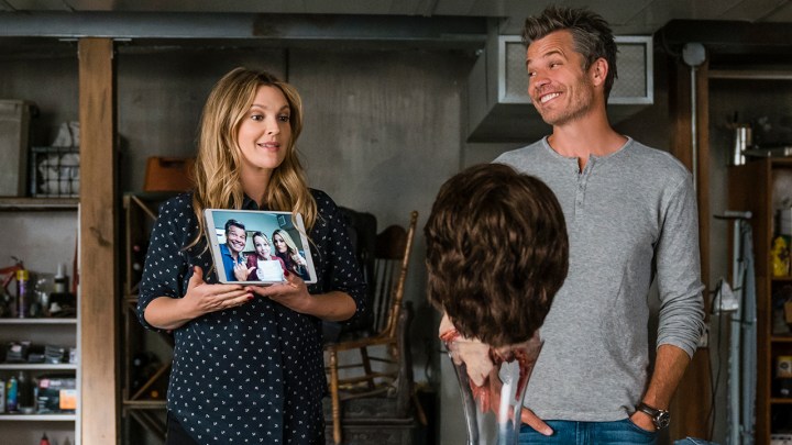 Drew Barrymore and Timothy Olyphant Sheila and Joel Hammond showing a photo to a severed head in Santa Clarita Diet.