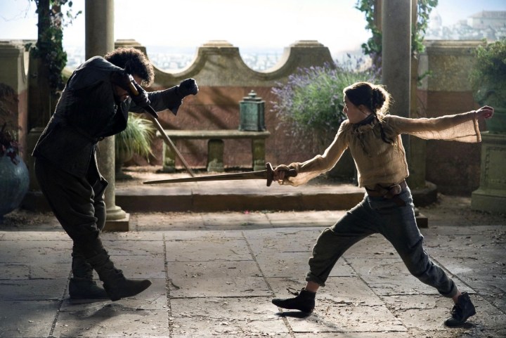 A man and young girl spar with swords.
