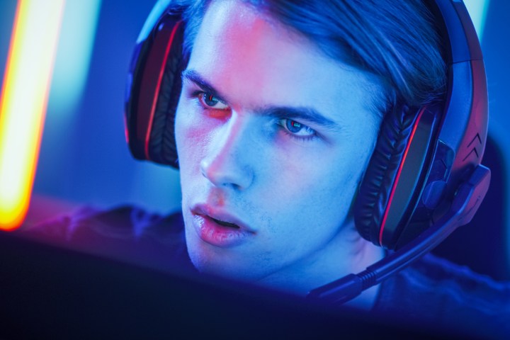 An intense-looking gamer with a gaming headset on.