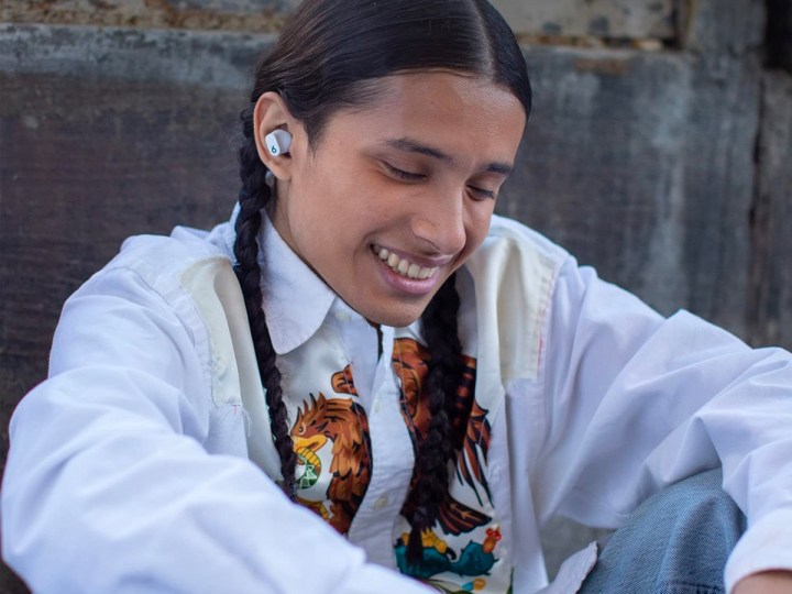 A young woman listens to music on her Beats Studio Buds.