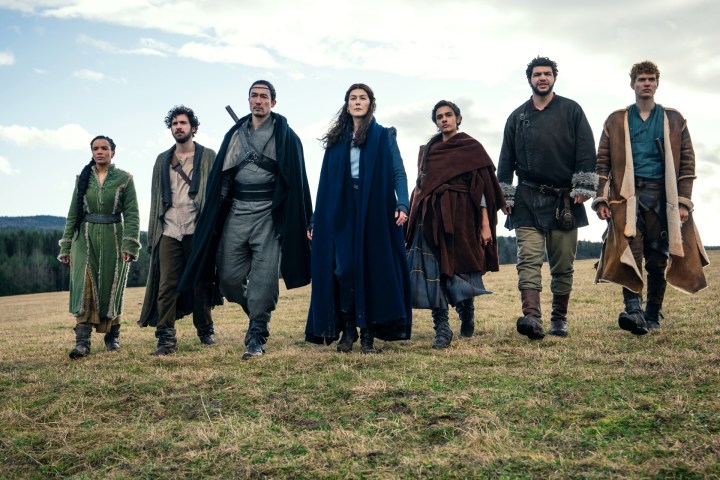 The cast of Amazon Studios' The Wheel of Time marches across a field.